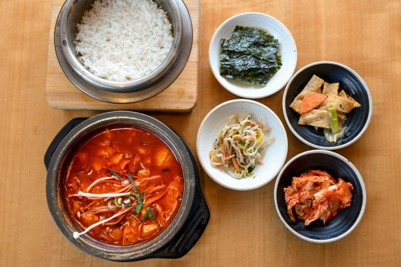 The signature tofu soup, sundubu-jjigae (bottom left), comes with banchan (snacks) and rice.
