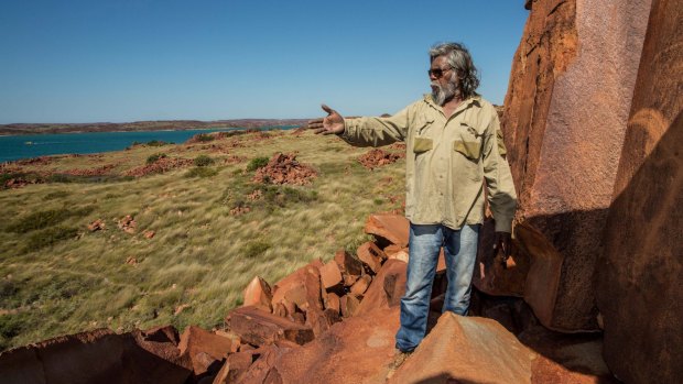 The rock art on the Burrup represent more than 30,000 years of continuous living culture. Senior cultural ranger at Murujuga National Park, Jakari Togo, looks out to sea next to rock carvings on the Burrup Peninsula.
