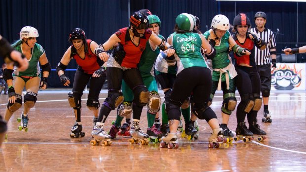 The Red Bellied Black Hearts taking on the Surly Griffins in the 2014 grand final of the Canberra Roller Derby League, with Bohemeth Rhapsody in the centre. 