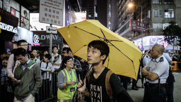 Fighting losing battle: A protester holds an umbrella as he and supporters stand in the Mong Kok district of Hong Kong.