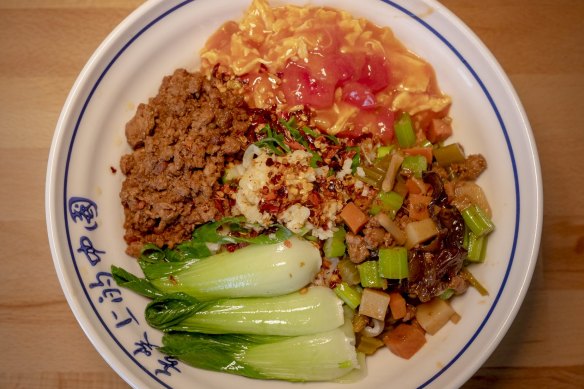 The dao xiao special biang noodle dish with pork mince, scrambled egg, potato, carrot and celery stir-fry and Asian greens.