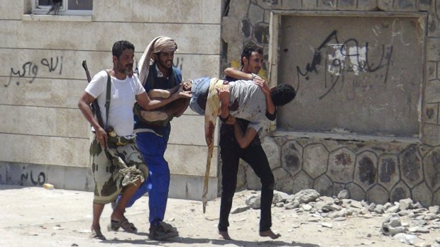 Fighters loyal to Yemen's President Abd-Rabbu Mansour Hadi carry a comrade who was injured during clashes with Houthi fighters in the country's southern port city of Aden.