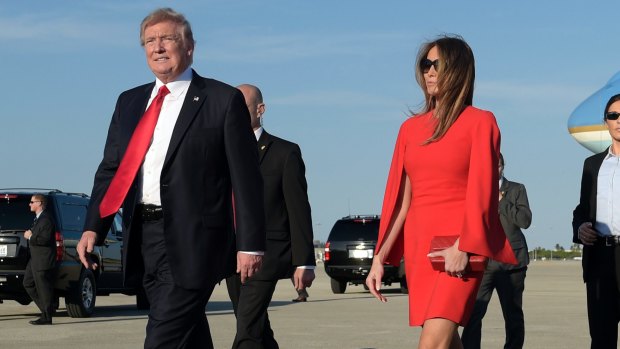 President Donald Trump walks with first lady Melania Trump.