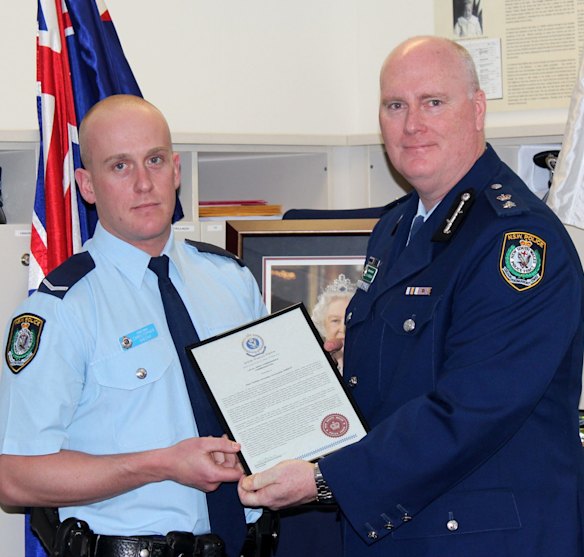 Chris Sheehy (left) receives a bravery award from Newtown Police Commander Simon Hardman in September 2015. The young officer was being covertly monitored during the same period on the  recommendation of his boss. 