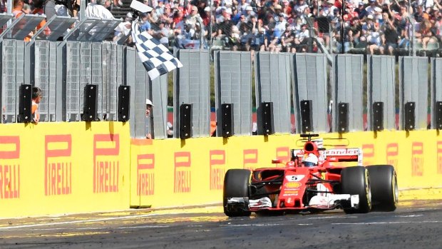 Ferrari's Sebastian Vettel crosses the line to claim victory.
