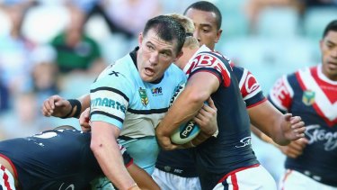 Recovering: Paul Gallen of the Sharks is tackled against the Roosters.