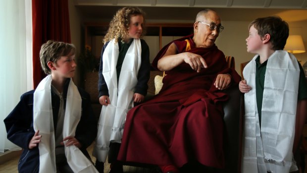 His Holiness the Dalai Lama  talks with Leura public school students Harry Skeggs 11 (left), Eliza Skeggs, 6, and Joe Skeggs, 9.
