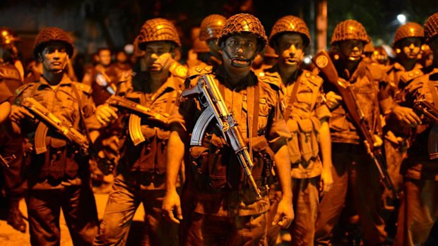 Bangladeshi security stand guard near a restaurant that has been attacked by gunmen.