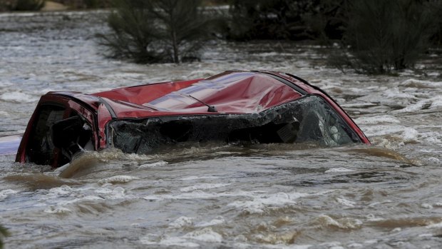 A four-wheel-drive vehicle in Paddys River upstream from the Cotter Reserve in the ACT. The driver died after trying to cross the raging torrent.