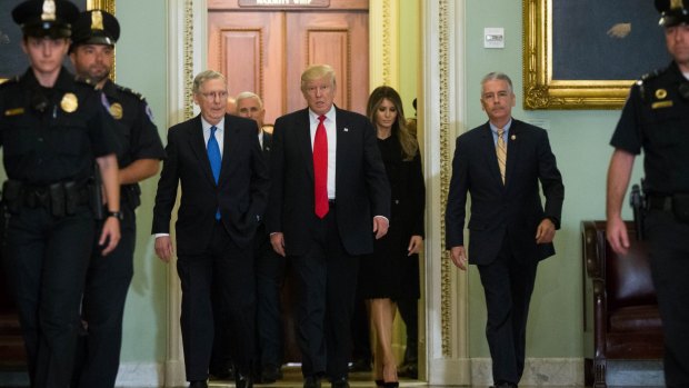 Senate Majority Leader Mitch McConnell walks with President-elect Donald Trump and his wife Melania before a meeting at the US Capitol.
