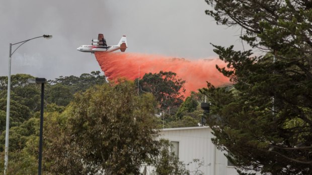 A waterbomber sprays fire retardant on bushland on the outskirts of Lorne on Christmas Day.