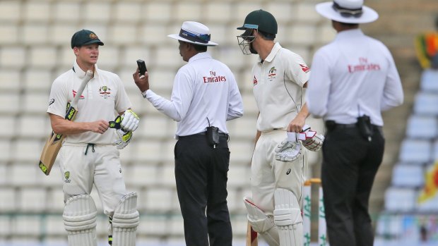 Australia's Steve Smith speaks with umpire Sundaram Ravi as the light fades on day four of the first Test between Sri Lanka and Australia.