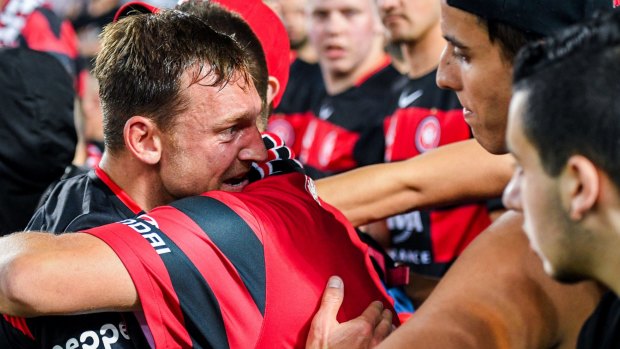 Started on the bench: Brendon Santalab is consoled by Wanderers fans after the 5-0 defeat.