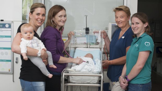 Emily O'Callahan with baby Jessica and Belinda Palmer checking her baby son Flynn Billings, Associate Professor Dr Zsuzsoka Kecskes and Corinne Henderson from Miracle Babies ACT. 