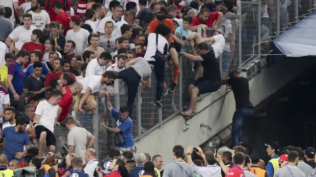 Spectators try to escape from the stands as clashes break out right after the Euro 2016 Group B soccer match between England and Russia.