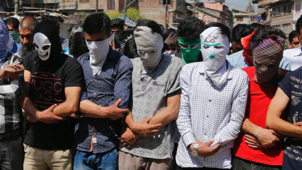Masked Kashmiri Muslims hold funeral prayers in absentia for rebel commander Sabzar Ahmed Bhat in Srinagar, the summer capital of India's Jammu and Kashmir state.