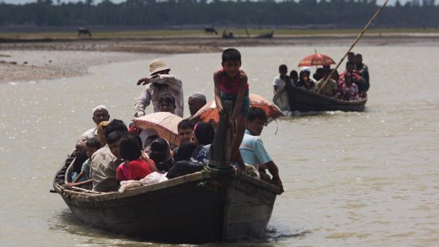 Myanmar's Rohingya cross a stream on Bangladesh side of the border near Cox's Bazar's. Tens of thousands more people have crossed by boat fleeing persecution in Myanmar.
