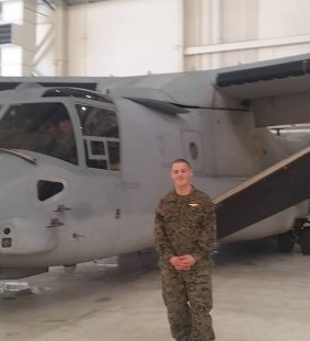 Nathan Ordway stands in front of a V-22 Osprey aircraft.