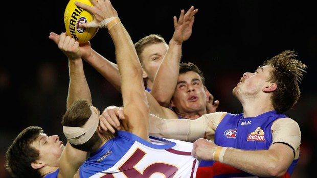 Justin Clarke and Jordon Bourke of the Lions compete for the ball with Tom Boyd and Jordan Roughead of the Bulldogs.