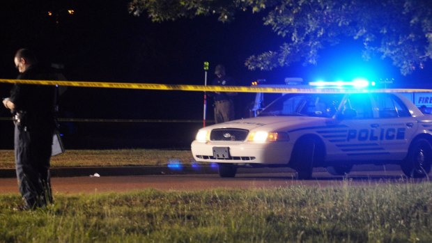 An officer investigates the scene where two Hattiesburg police officers were shot dead.