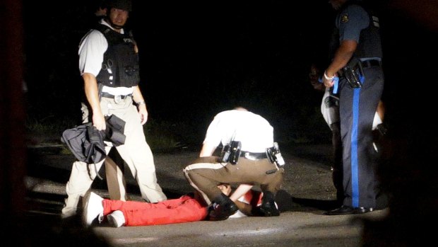 Man tended to by police after being shot in the town of Ferguson, Missouri.