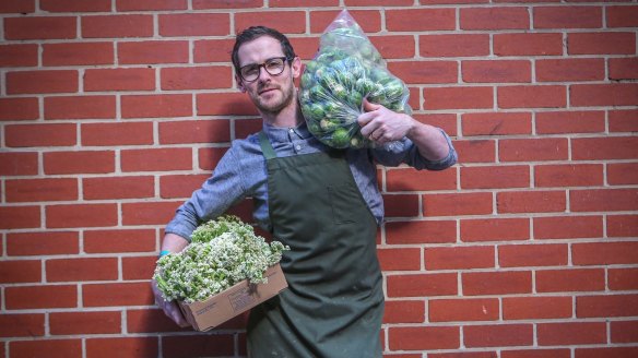 Chef Nate Wilkins with brussels sprouts and cauliflower for his Higher Ground restaurant.