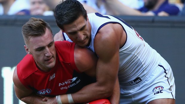 Melbourne's Lynden Dunn is challenged by Fremantle's Matthew at the MCG on Sunday.