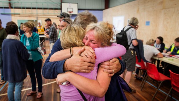 Wye River locals comfort each other at the Apollo Bay Relief Centre. 
