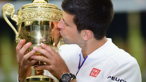 Djokovic celebrates with the trophy.