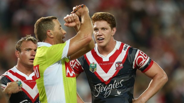 Busy day: Referee Ben Cummins places Roosters prop Dylan Napa on report on Monday.