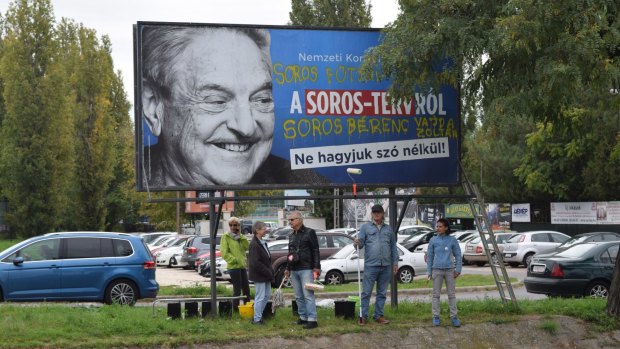 Activists stand in front of an anti-George Soros billboard. Soros said oppression of the opposition by Orban's government is greater than when Hungary was under Soviet domination. 