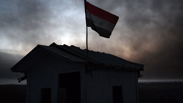 Smoke from an oilfield that was set aflame by retreating ISIS fighters ahead of the Mosul offensive hovers over an Iraqi checkpoint on on October 21. 