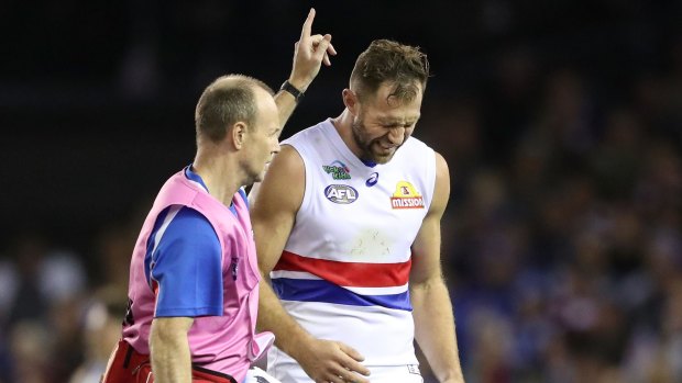 Travis Cloke is helped from the field on Friday.