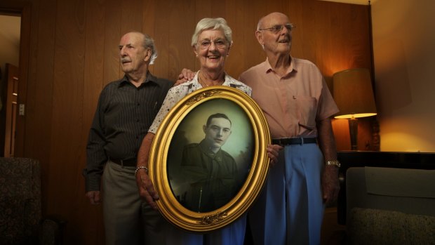 Keith Huntsman, Jean Oldfield and Clive Huntsman hold a photograph of their uncle Henry Huntsman.