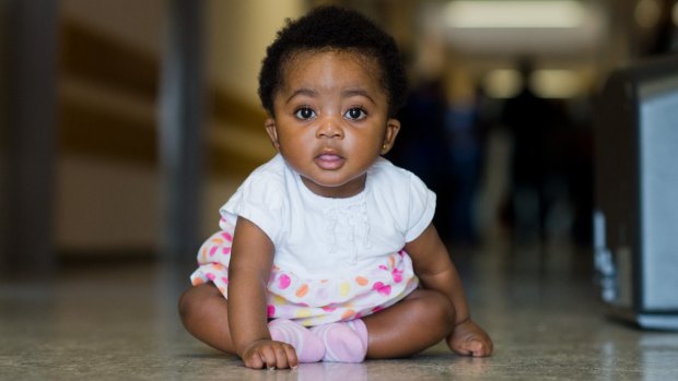 Angela Merkel Ade, 6 months, sits in a corridor in the Oststadtkrankenhaus refugee accommodation in Hanover, Germany. Her mother Ophelya Ade, 26, named her after the German chancellor. 