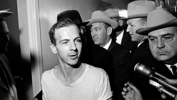 Lee Harvey Oswald talks to the media as he is led down a corridor of the Dallas police station in 1963.