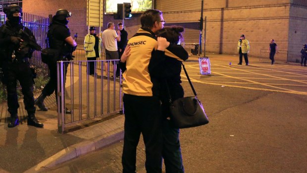 A woman is consoled outside Manchester Arena following the explosion. 