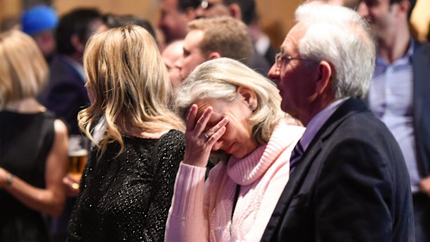 Malcolm Turnbull supporters listen to Bill Shorten give his speech on the screen at the Liberal Party election night function in Sydney.