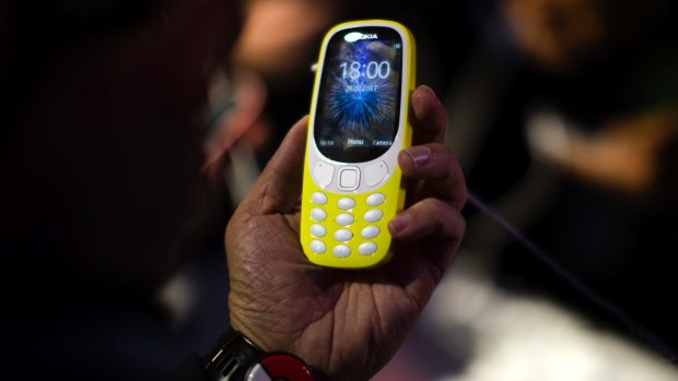 Attendants check the new re-launched Nokia 3310 phone, during a Nokia presentation ahead of Monday's opening of the Mobile World Congress. 