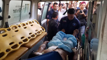 A Pemon indigenous man is loaded into an ambulance after he was shot and wounded when clashes erupted  in Santa Elena, Venezuela. 