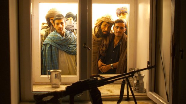 Afghans look through the window into the bedroom of Taliban leader Mullah Mohammad Omar as they go through his compound on the outskirts of the Afghan city of Kandahar in 2001.