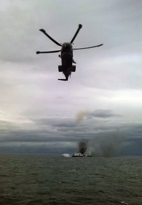 A helicopter joins the rescue operation on the stricken ferry.