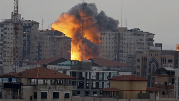 Selective targeting: A ball of fire rises from the al-Zafer apartment tower in Gaza City after an Israeli air strike on Saturday.