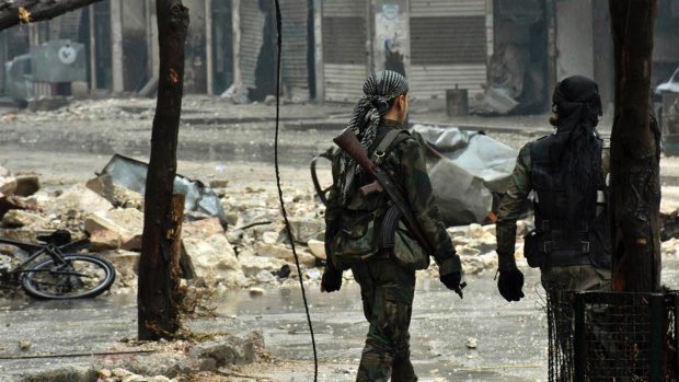 Syrian troops and pro-government gunmen march through the streets of east Aleppo on Tuesday.