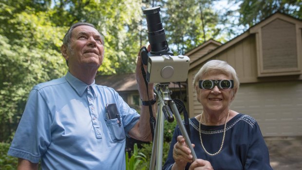 Donald and Norma Liebenberg stand in the driveway of their home in Salem, S.C. Donald has seen and blogged about his 26 eclipses for Clemson University where he does research.