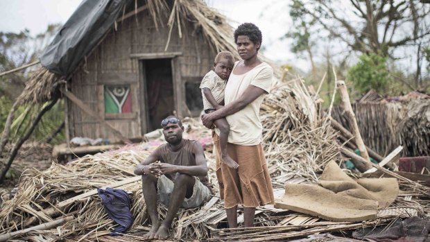 Masau Kalia and wife Nalin and child at their destroyed home on the island of Tanna.