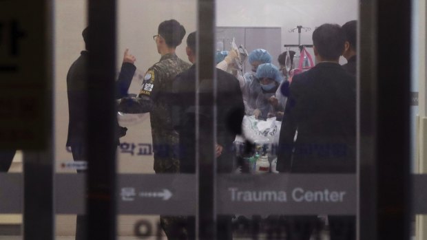 A South Korean army soldier, second from left, is seen as medical members treat an unidentified injured person, believed to be a North Korean soldier, at a hospital in Suwon, South Korea.