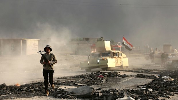 Iraqi soldiers are seen outside the city of Mosul on Wednesday, on the third day of the battle to retake the city from IS.