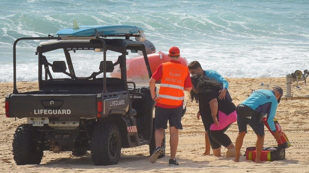 Mother Sandra Tomano is helped by lifesavers' buggy on Tuesday.