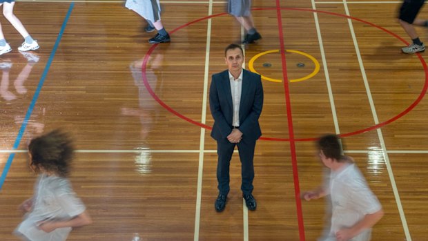 Mr Ferra with students on the basketball court.